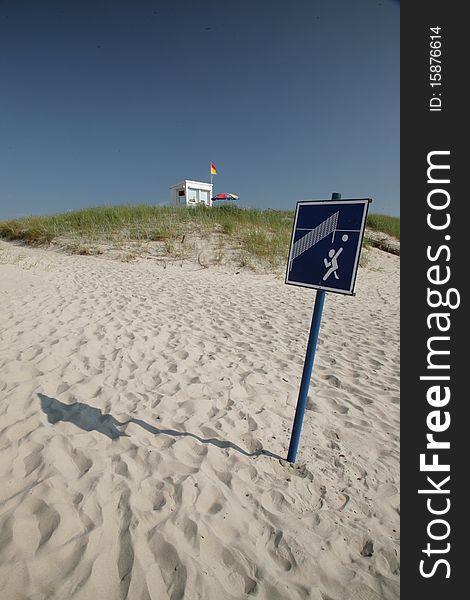 Empty beach with sign and rescue house