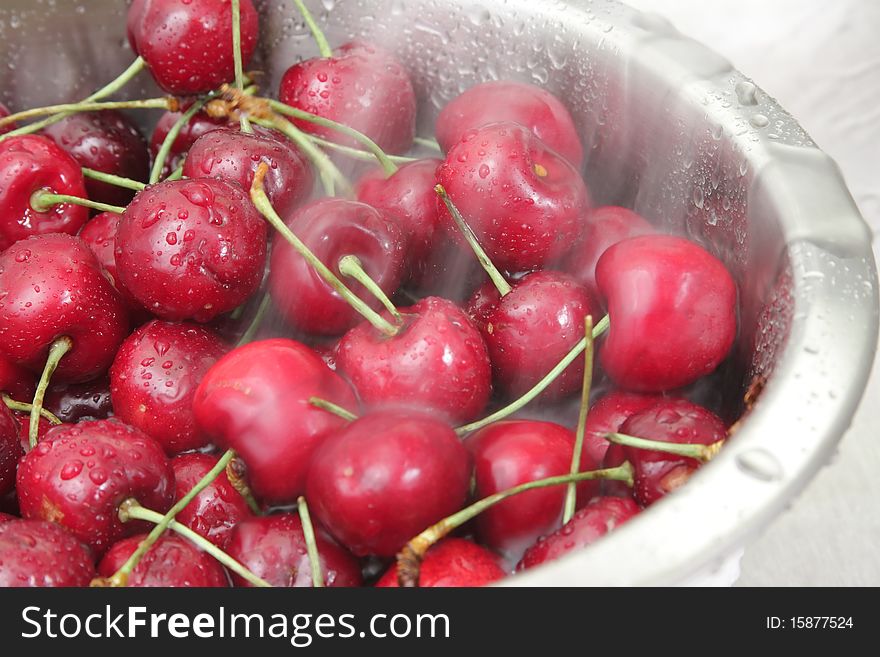 Washing a bowl of cherries under running water.