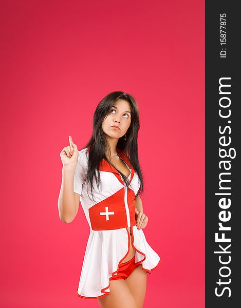 Sensual brunette nurse posing on color background
