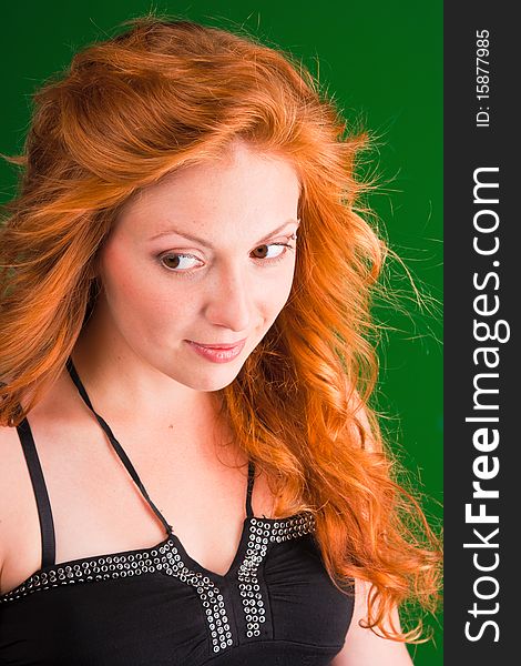 Beautiful red-haired woman with a worried look in black sarafan on a green background. Beautiful red-haired woman with a worried look in black sarafan on a green background