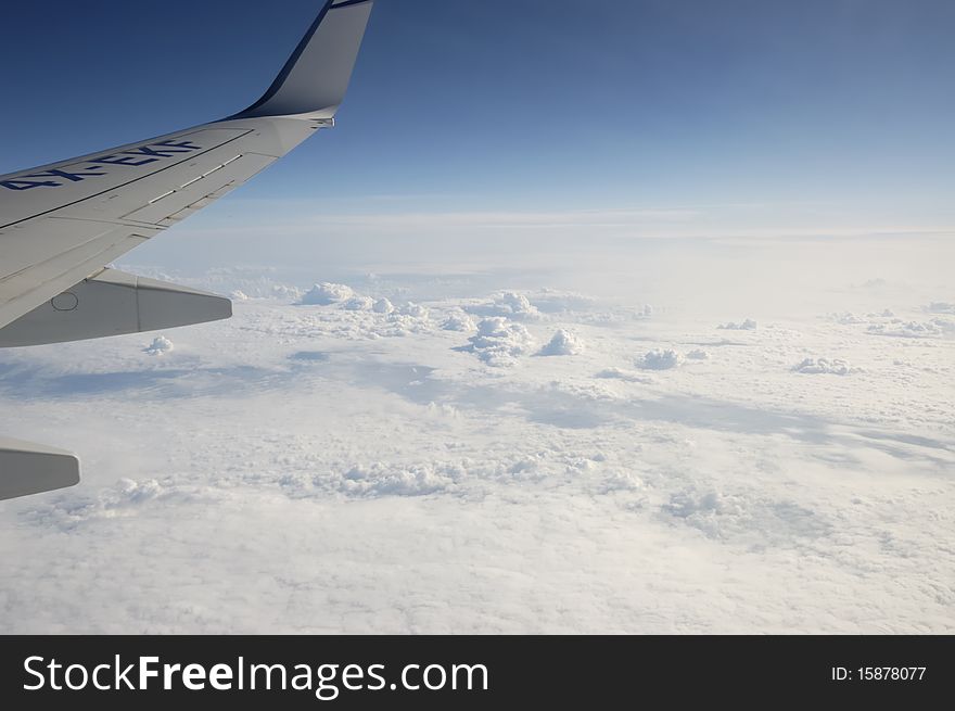 View of jet plane wing with cloud patterns above North Atlantic. View of jet plane wing with cloud patterns above North Atlantic.