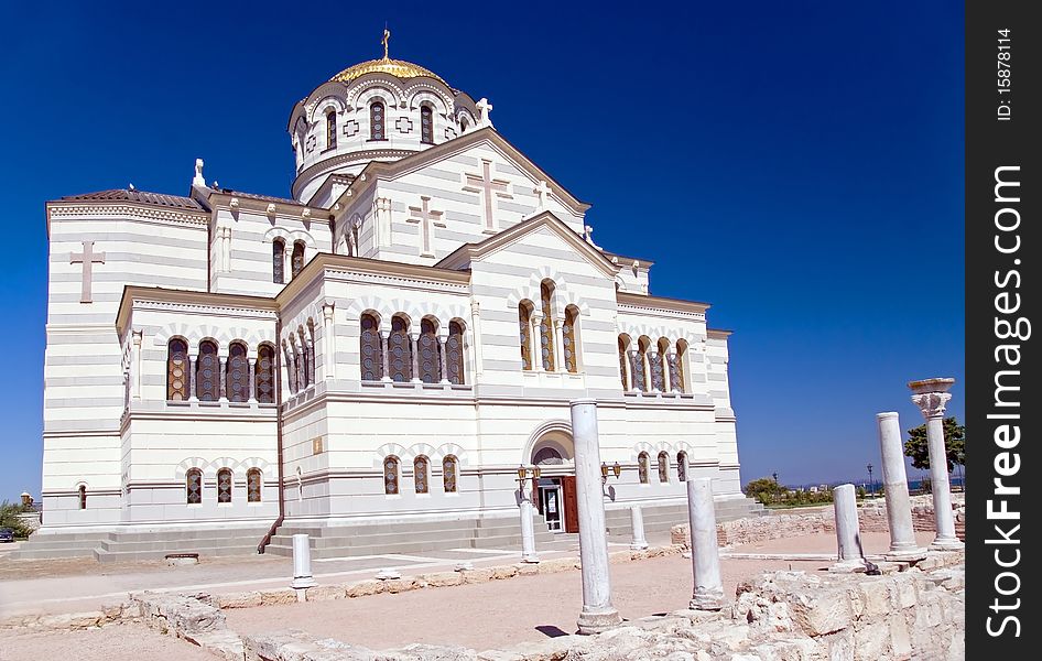 Ancient ruins against orthodox church