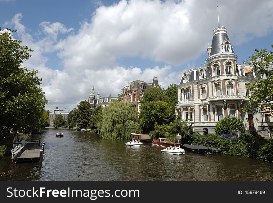 Amsterdam canal and splendid mansion in historical center of the city in summer day. Amsterdam canal and splendid mansion in historical center of the city in summer day.
