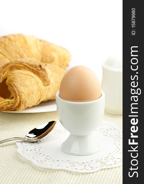 Breakfast table with egg and croissants