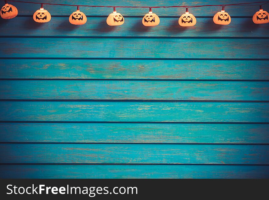 Scary pumpkin garland against wooden background. Happy Halloween concept. Scary pumpkin garland against wooden background. Happy Halloween concept