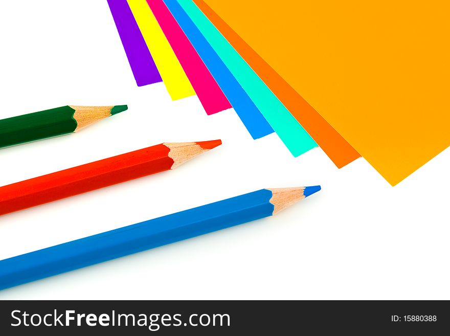 Multicolored paper and pencils isolated on white background