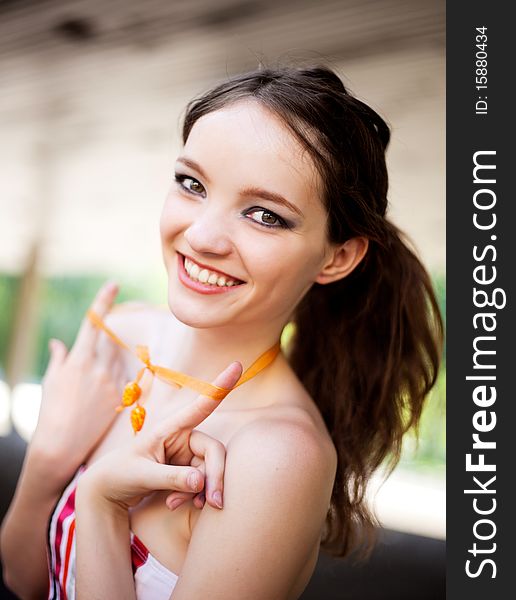 Portrait of a happy young laughing girl wearing a necklace