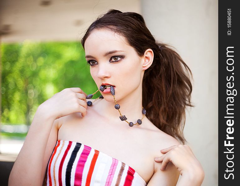 Portrait of a beautiful young brunette model wearing beads