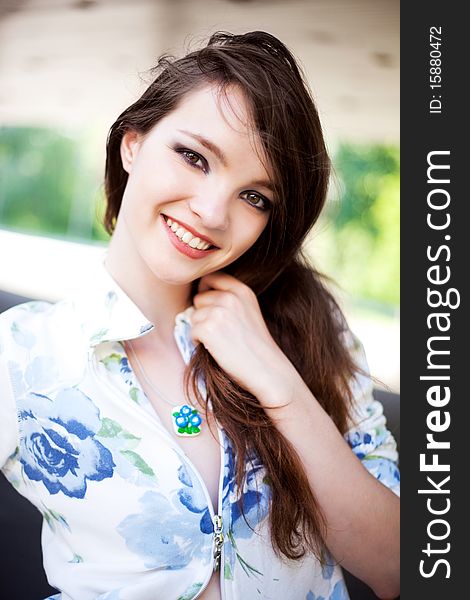 Portrait of a happy lovely young laughing girl wearing a necklace