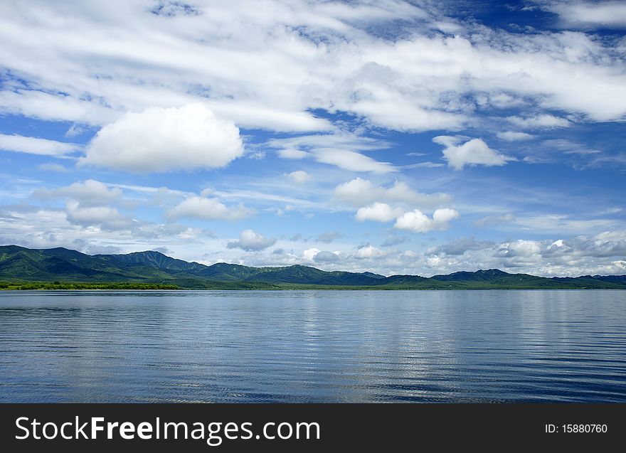 Landscape, with lake mountains and clouds in the dark blue sky. Landscape, with lake mountains and clouds in the dark blue sky.