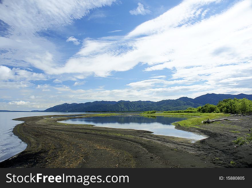 Landscape, with lake mountains and clouds in the dark blue sky. Landscape, with lake mountains and clouds in the dark blue sky.