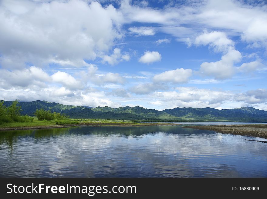 Landscape, with lake mountains and clouds in the dark blue sky. Landscape, with lake mountains and clouds in the dark blue sky.