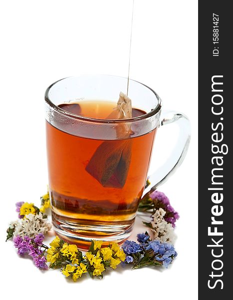 Hot tea in glass cup with flowers. Isolated on white background. Hot tea in glass cup with flowers. Isolated on white background