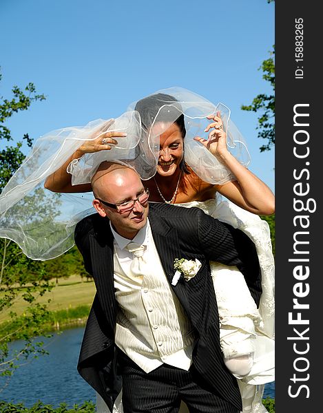 Groom is lifting his bride up in a park. Groom is lifting his bride up in a park.