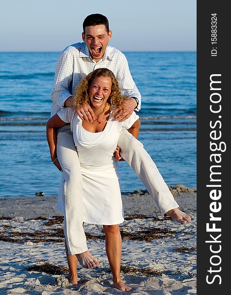 A happy woman and man having fun on beach.