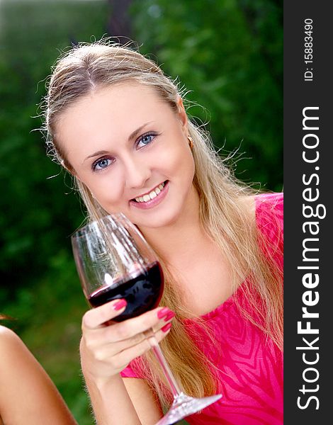 Beautiful girl drinking wine in the park