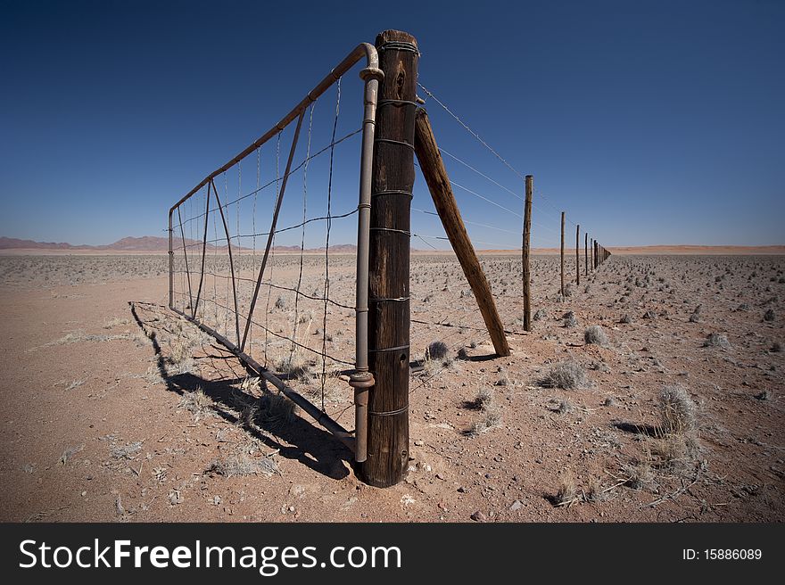 Gate somewhere in Namibia with fence disappearing in the distance. Gate somewhere in Namibia with fence disappearing in the distance.