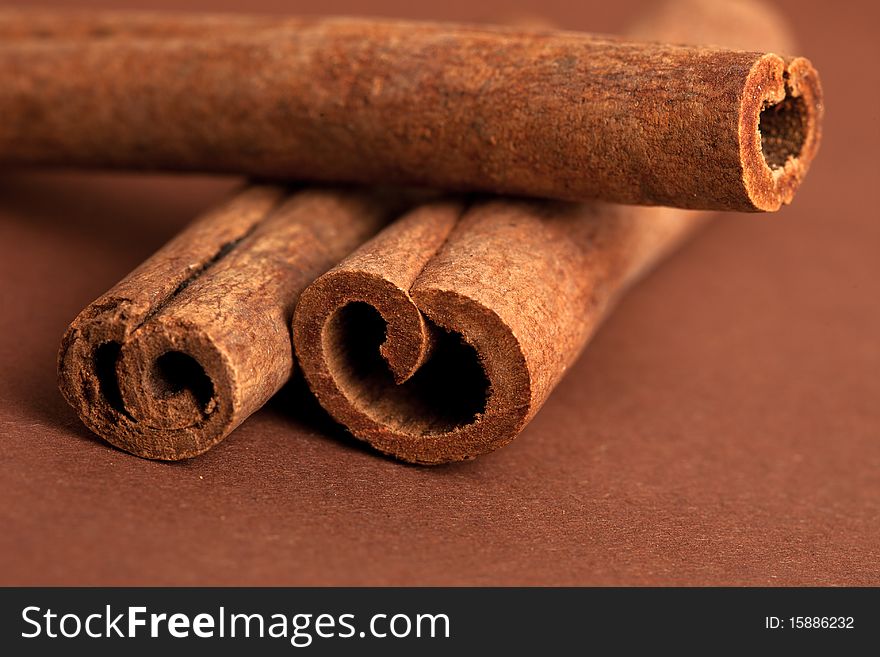 Cinnamon sticks on brown background