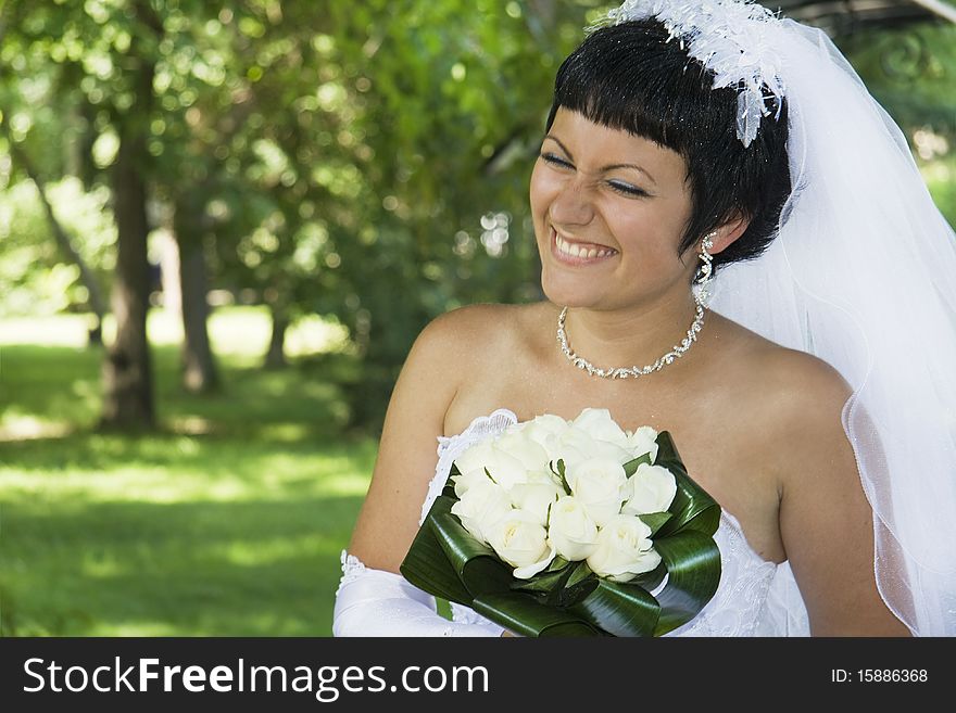 Beautiful and happy bride with a bouquet outdoors. Beautiful and happy bride with a bouquet outdoors.