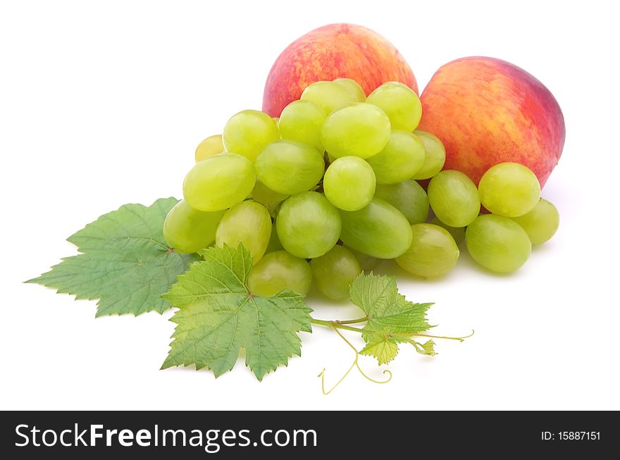 Cluster of grapes and two ripe peaches on a white background. Cluster of grapes and two ripe peaches on a white background