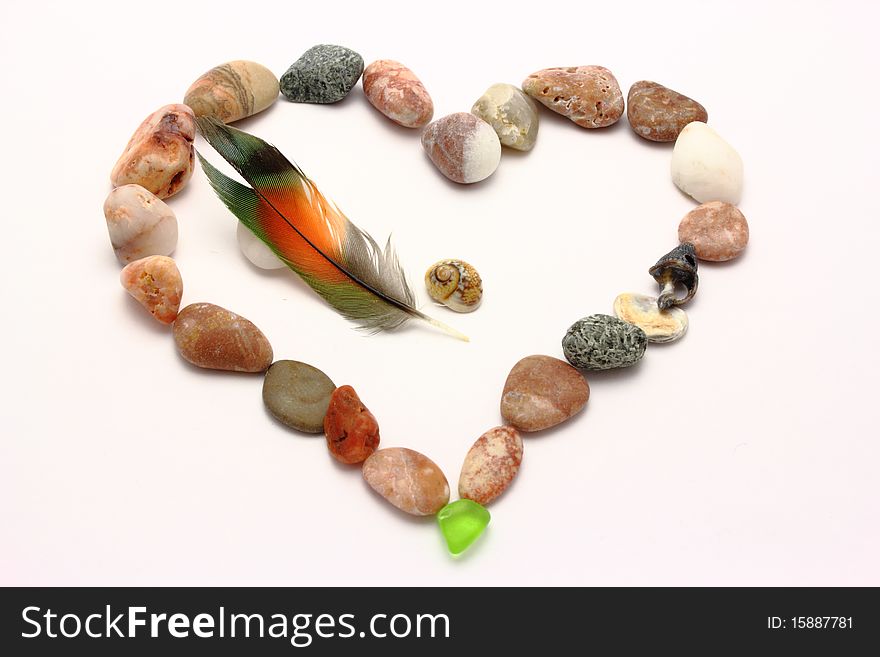 Heart from stones and a parrot feather