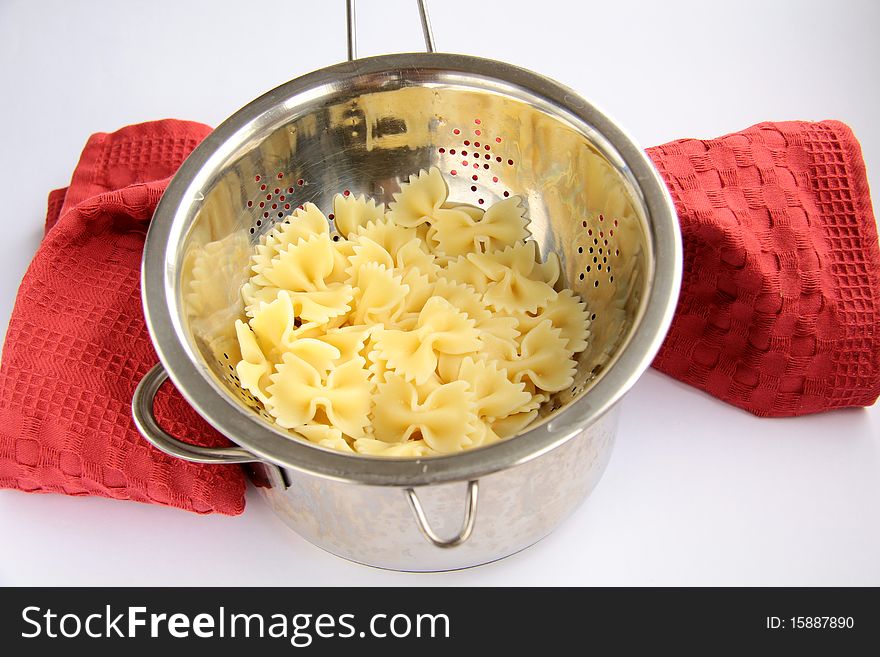 Pasta in a saucepan with a napkin on a white background