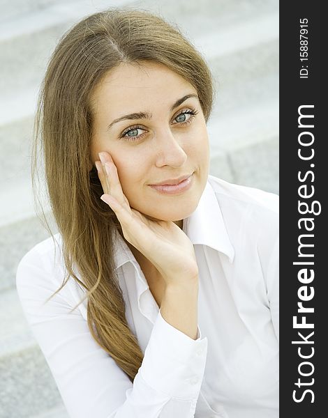 Portrait of a young woman smiles on the background of the stairs and office space. Portrait of a young woman smiles on the background of the stairs and office space