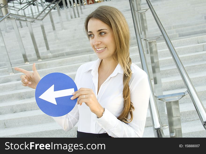 Close-up of a young woman gesturing. In the hands of a traffic sign