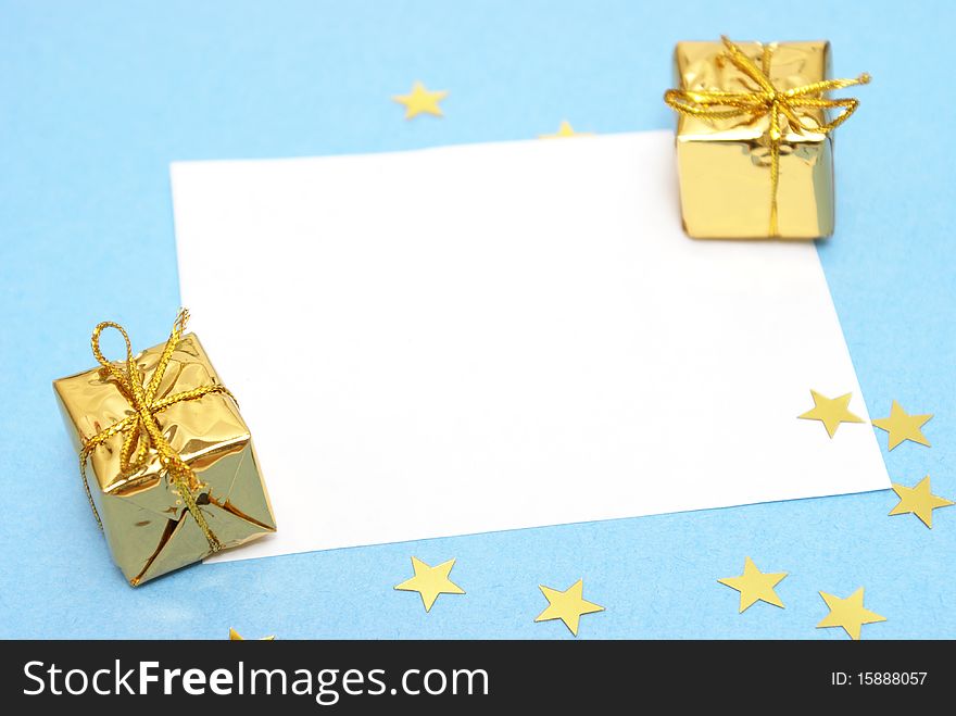 A blank Christmas note with two decorative gifts.