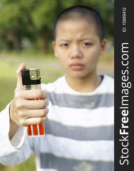 Bald person holding large lighter outdoors