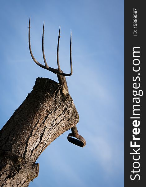 Pitch fork resting on tree stump awaiting use. Pitch fork resting on tree stump awaiting use.