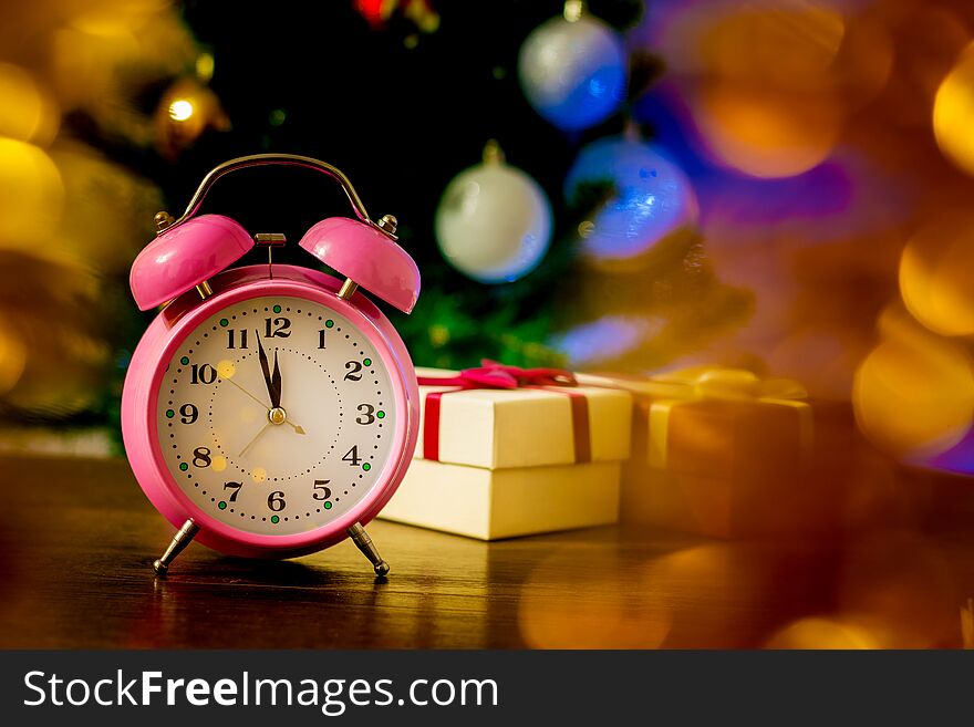 Clock and gift boxes near Christmas tree on New Year`s Eve_