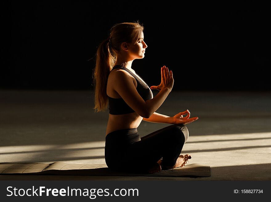 Sporty young girl is meditating alone.