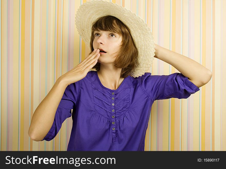 Beautiful girl in a straw hat on a background of striped walls. Emotions. Beautiful girl in a straw hat on a background of striped walls. Emotions