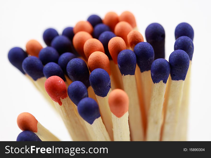 Blue and orange colored matchsticks on white background