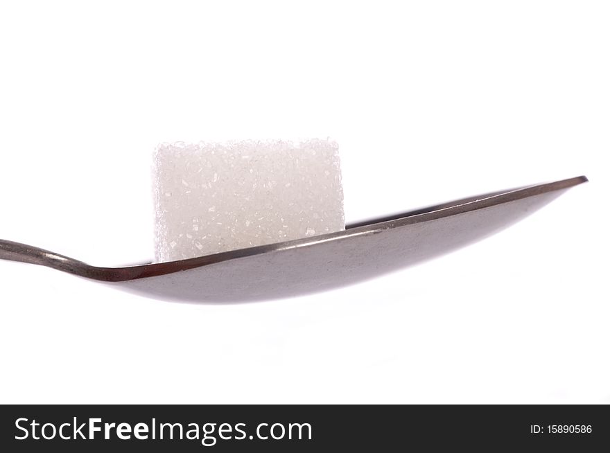 White sugar cube on tea spoon cutout