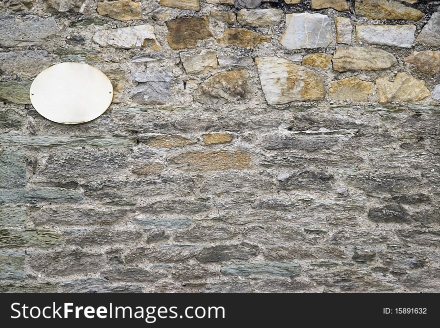 Blank sign for street name on stone wall. Blank sign for street name on stone wall