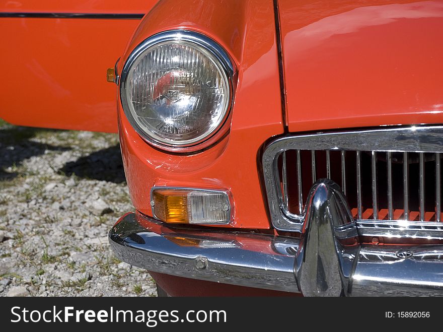 Right front light of a red vintage car. Right front light of a red vintage car