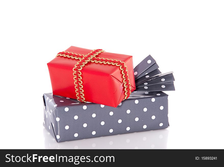 A colorful grey dotted present with a red gift on top isolated on white. A colorful grey dotted present with a red gift on top isolated on white