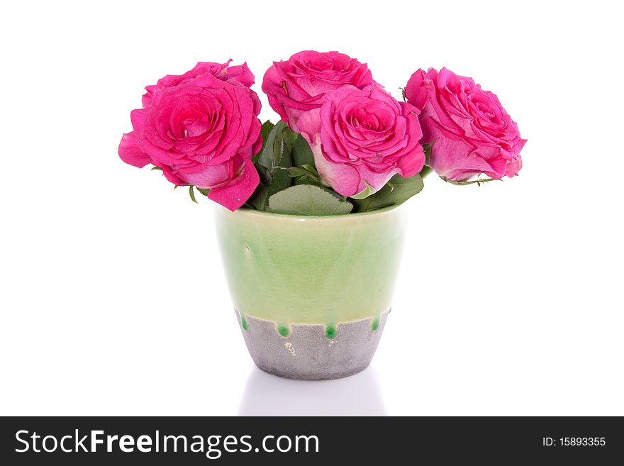 A bouquet of pink roses in a green vase isolated over white. A bouquet of pink roses in a green vase isolated over white