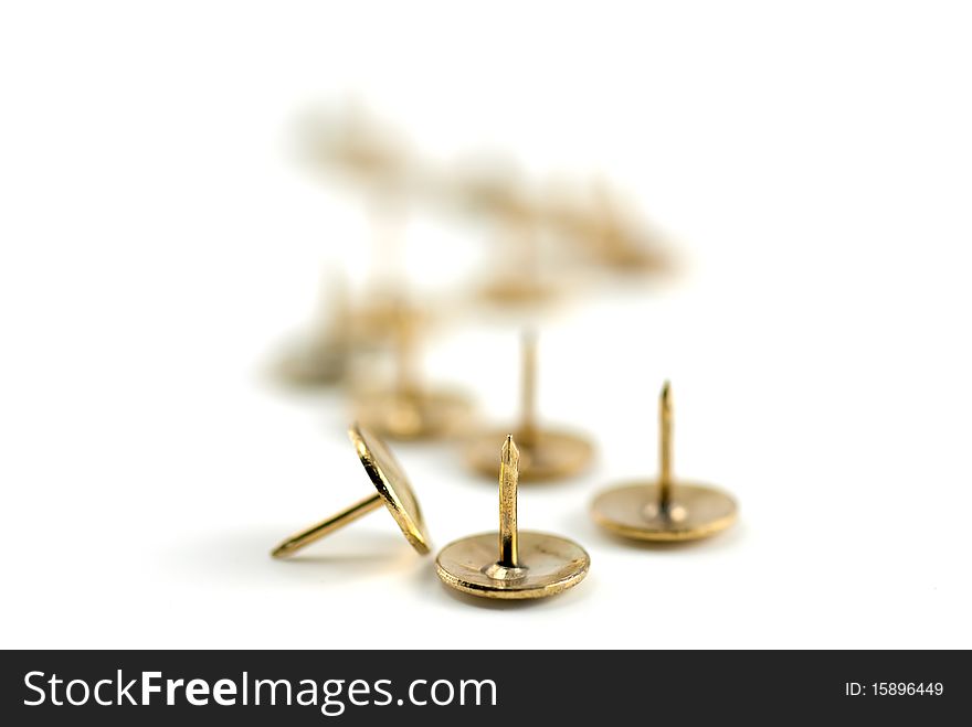 Studio shot of the golden pushpins on white background