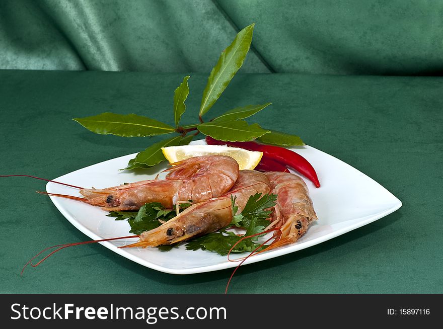 Plate of crayfish with parsley on a green background. Plate of crayfish with parsley on a green background