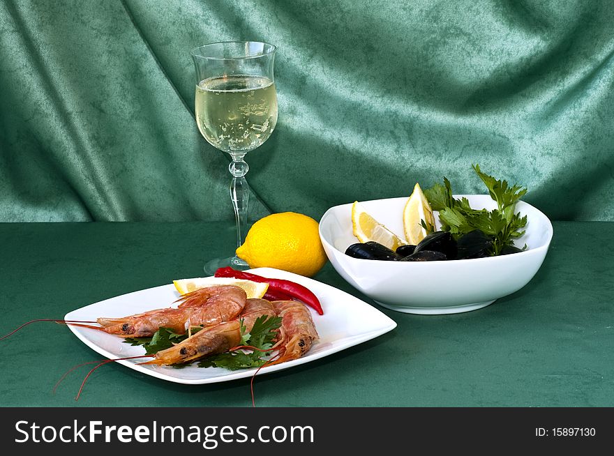 Plate of crayfish and mussels with parsley on a green background. Plate of crayfish and mussels with parsley on a green background