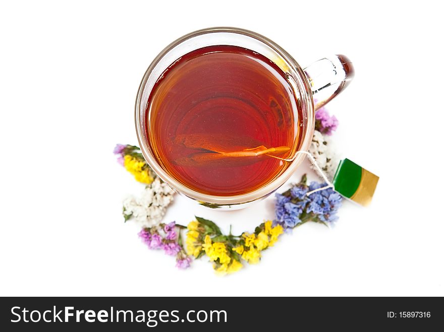 Hot tea in glass cup with flowers. Isolated on white