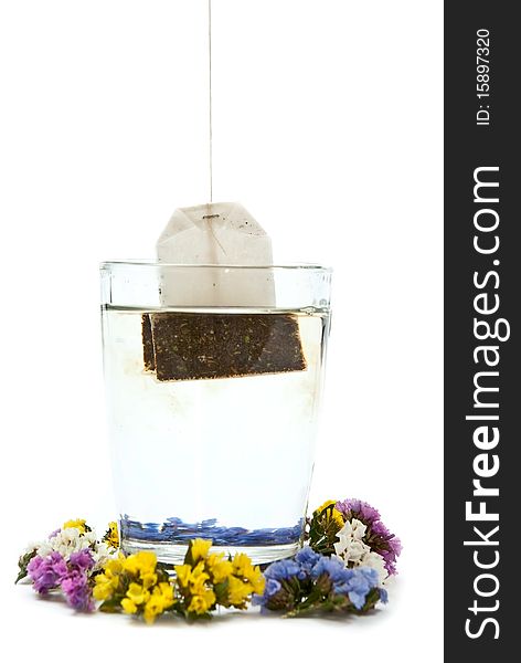 Hot tea in glass cup with flowers. Isolated on white background. Hot tea in glass cup with flowers. Isolated on white background