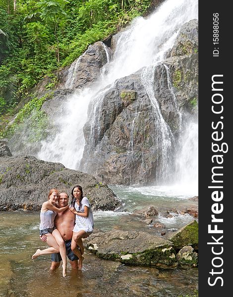 Rest at the waterfall, man carry children and stand in the water