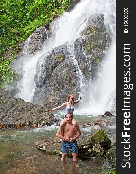 Rest at the waterfall, man carry children and stand in the water