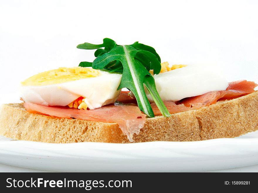 Delicious sandwich with salmon, hard-boiled egg and rucola. Nutritious breakfast