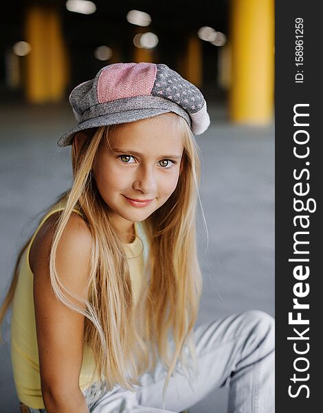 Portrait of a beautiful girl with long blond hair in hat
