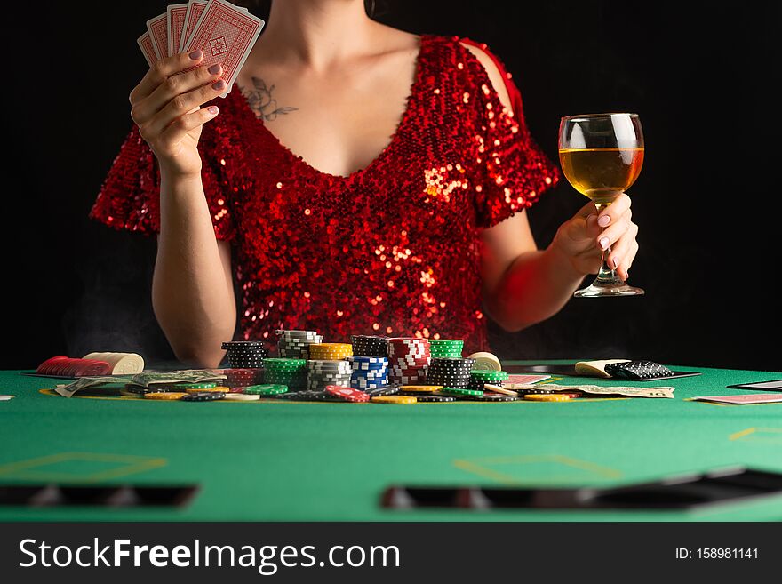 Girl In Evening Dress Plays Poker In A Casino. Focus On The Card And Focus